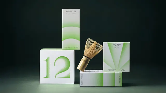 Matcha carton packaging with bamboo whisk, photographic, minimal, dark