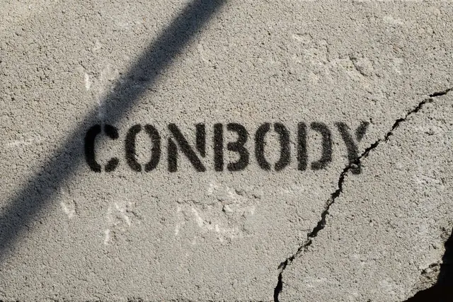 CONBODY stencil sprayed on cracked concrete, brutalist, photographic, light