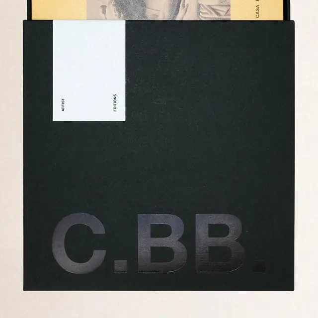 Black slipcase with tonal gloss-on-matte initials, minimal, editorial, dark