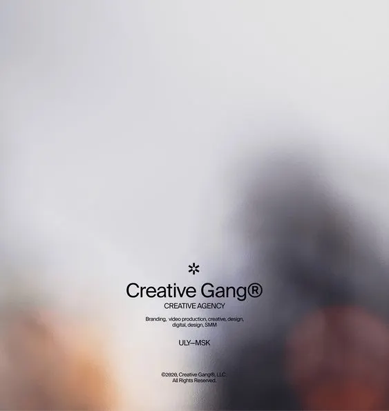 Centered agency wordmark over blurred photo, minimal, photographic, light