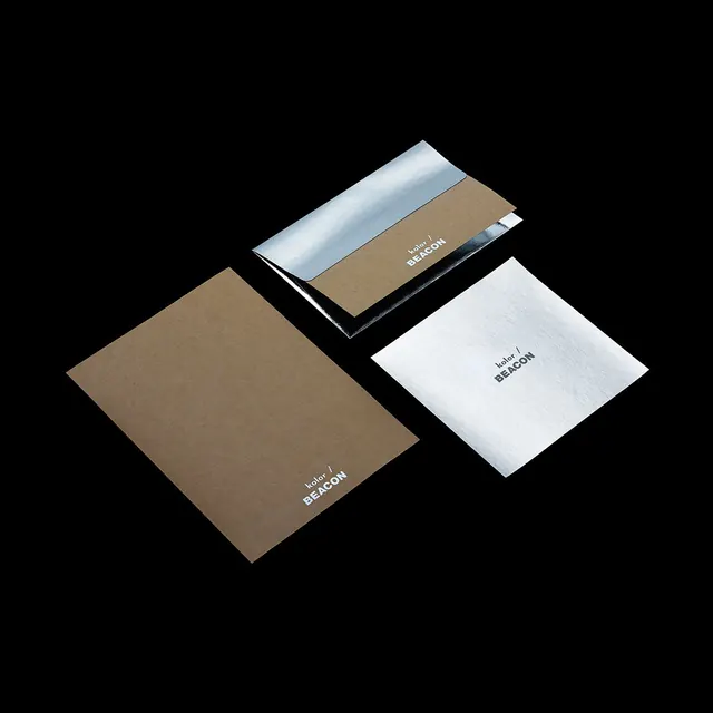 Kraft and silver-foil stationery on black, minimal, monochrome, dark