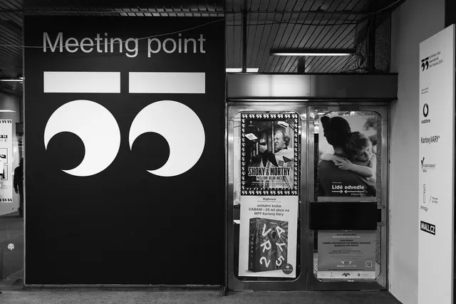 Karlovy Vary IFF meeting-point wall with oversized 55 numeral mark, monochrome, typographic, monochrome