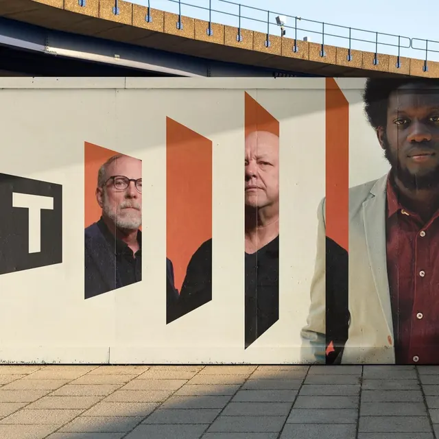 Outdoor portrait installation with burnt-orange frames, geometric, editorial, light