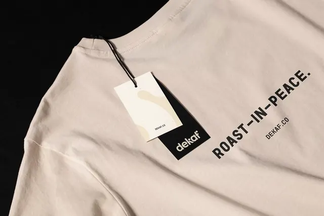 Cream apparel label with dark typographic detail, minimal, monochrome, light