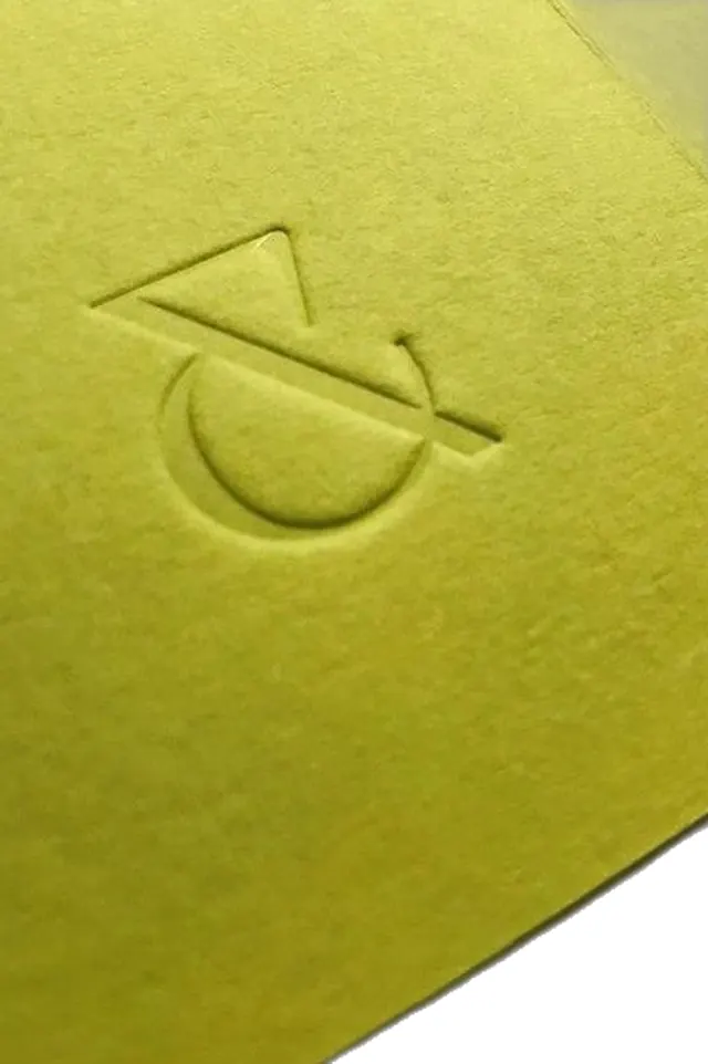 Debossed mark on pale yellow packaging, minimal, light