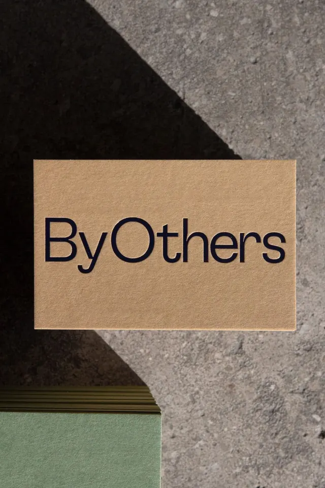 ByOthers wordmark on kraft paper, minimal, corporate-clean, earthy