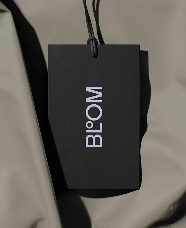Bloom black hangtag with lavender wordmark, minimal, monochrome, dark