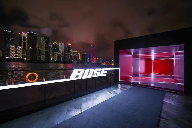 Bose waterfront installation with illuminated wordmark, photographic, cinematic, dark