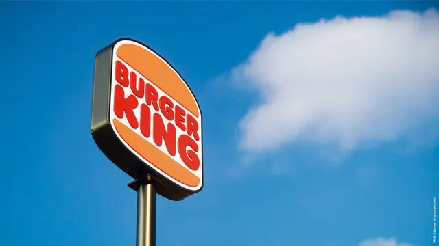 Burger King pylon sign against blue sky, photographic, retro, vibrant