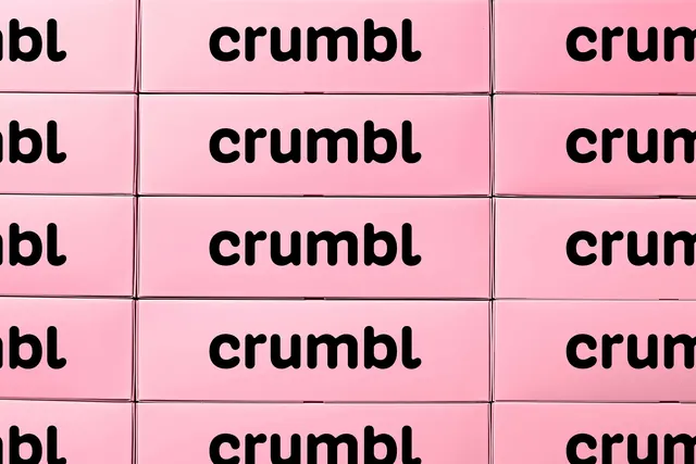 Crumbl pink cookie boxes stacked into a wordmark grid, minimal, photographic, light