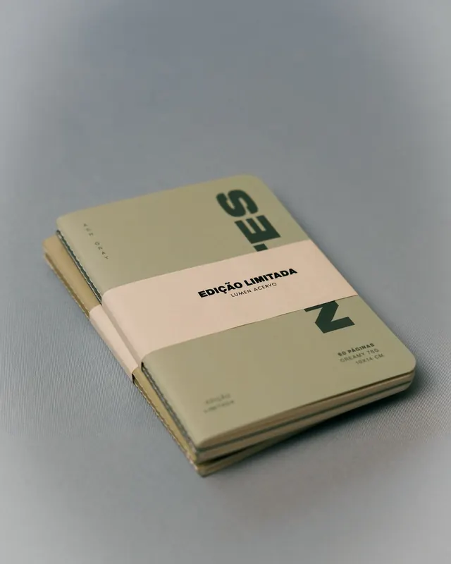 Stacked notebooks with cream band and serif wordmark, minimal, editorial, light