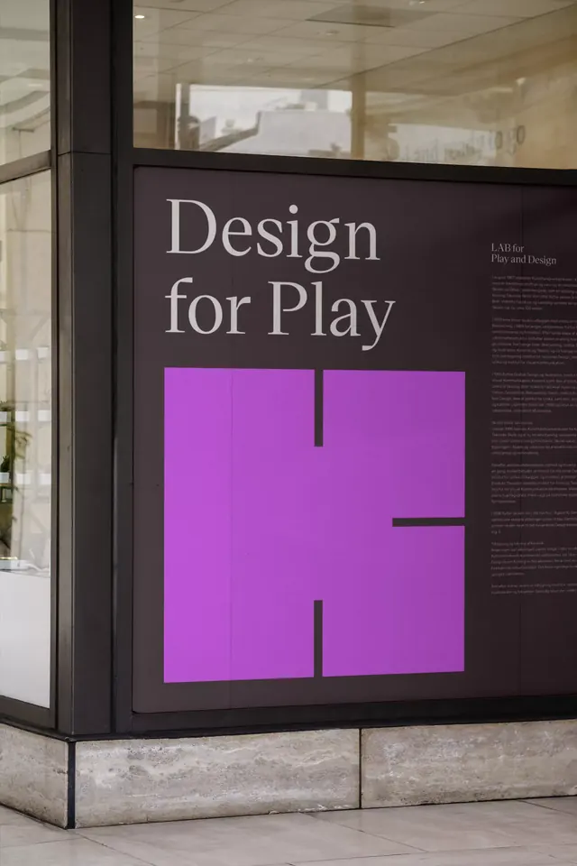 Design for Play storefront display with magenta geometric cutout, minimal, geometric, dark