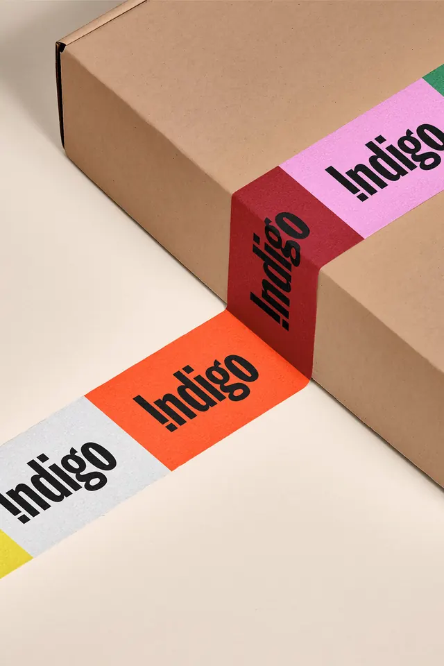 Indigo colour-blocked packing tape on kraft box, flat, typographic, warm