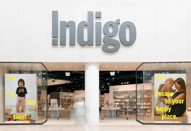 Indigo storefront with dimensional grey fascia lettering, minimal, architectural, light