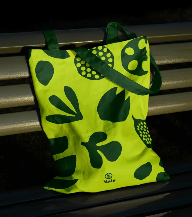 Main lime tote bag on a park bench, photographic, illustrated, vibrant