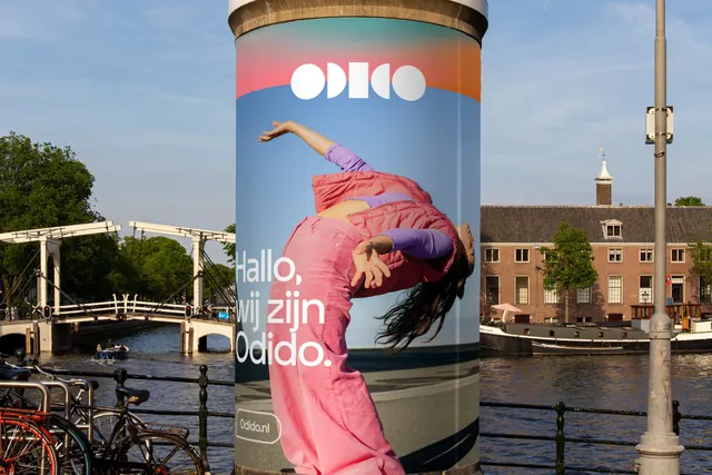 Odido advertising column with dancing figure and gradient sky, photographic, gradient-heavy, vibrant