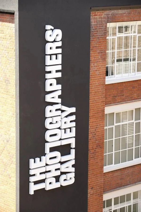 White bold typography on dark storefront signage, minimal, swiss, dark