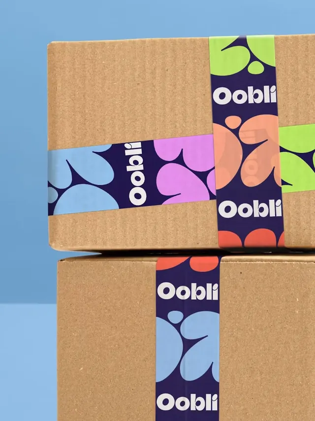 Oobli branded packing tape on stacked kraft boxes, photographic, flat, cool
