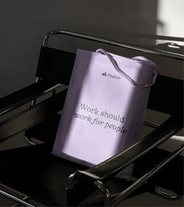 Peakon lilac tote bag on a tubular steel chair, photographic, minimal, dark