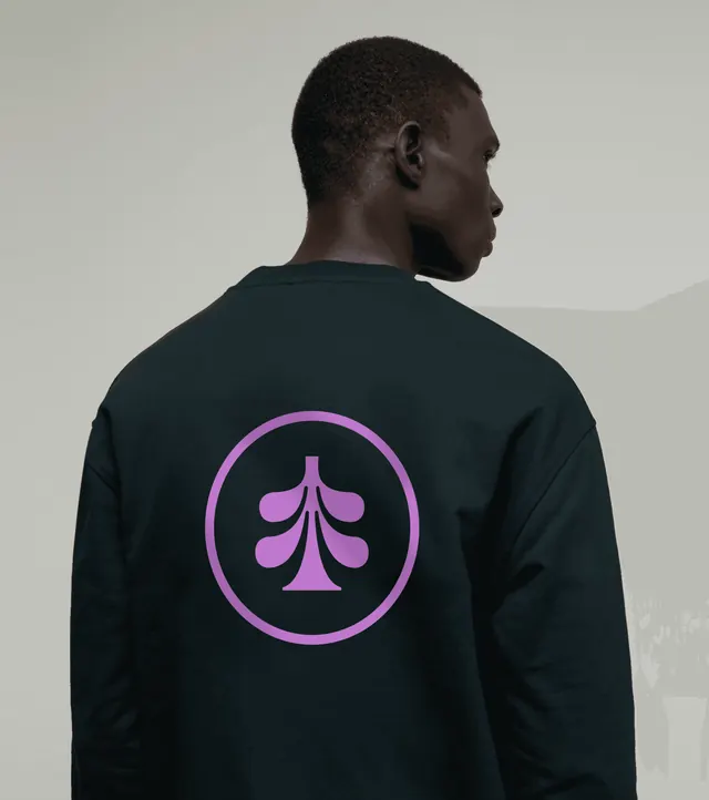 Planted circular tree mark on a dark green sweatshirt, photographic, minimal, dark