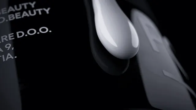 Pomalo packaging macro with cream droplet, minimal, dark-mode, dark