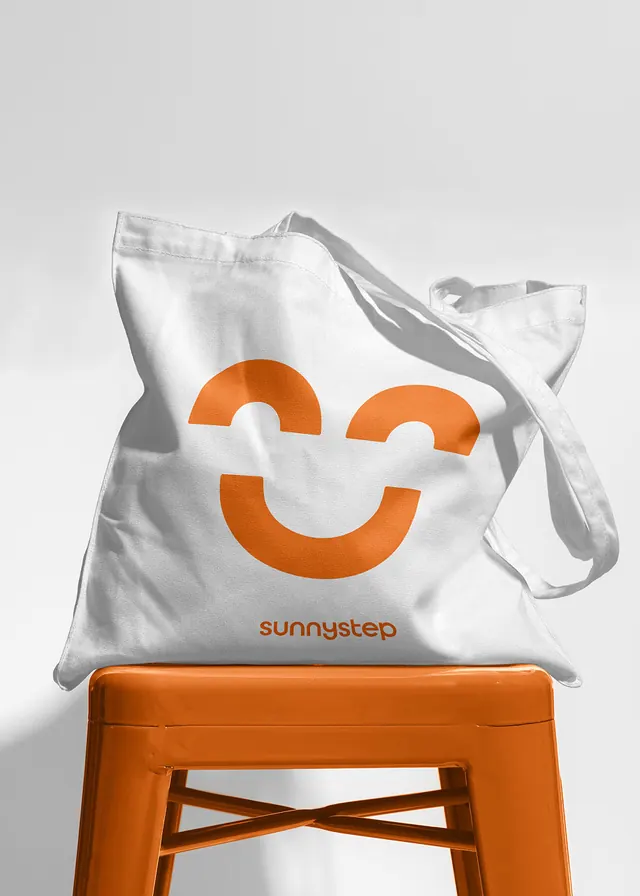 SunnySTEP smile mark tote on orange stool, minimal, photographic, light