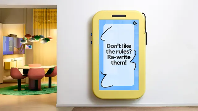 Oversized phone-shaped wall installation with brand copy, playful, illustrated, vibrant
