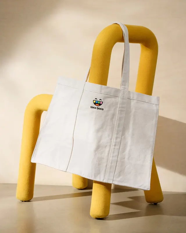 Natural canvas tote with small embroidered logo, minimal, playful, warm