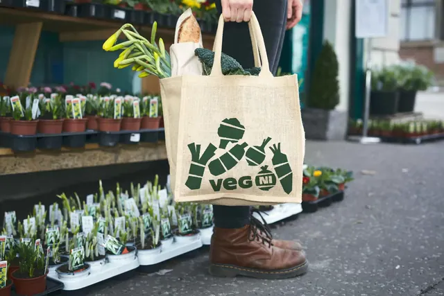Veg NI jute tote bag at a market stall, photographic, flat, earthy