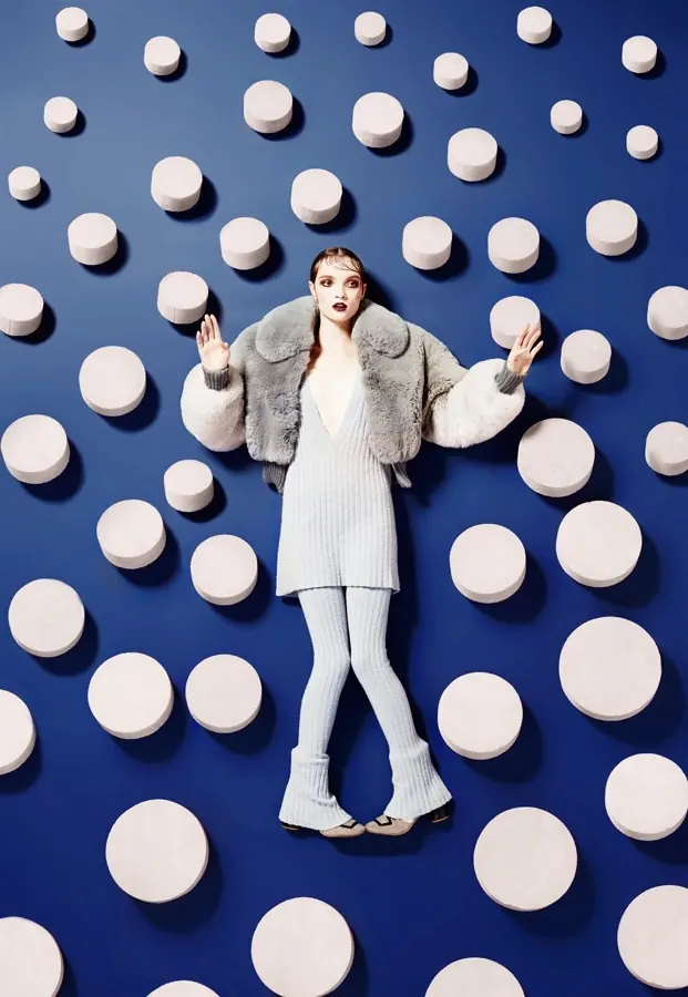 Fashion editorial with figure against oversized circles, photographic, editorial, vibrant