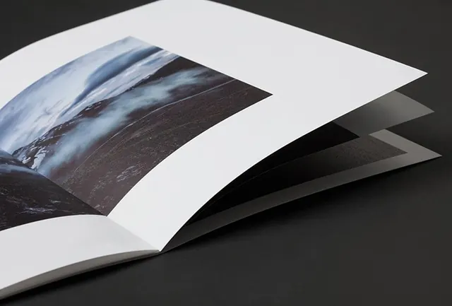 Open book with full-bleed landscape photograph, minimal, editorial, light