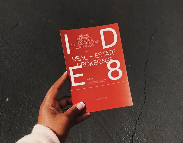IDE8 red business card in hand, minimal, corporate-clean, vibrant
