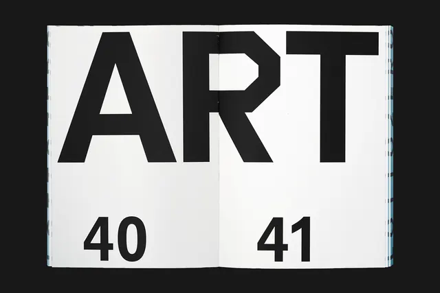 Bold ART typography in open book spread, minimal, editorial, dark