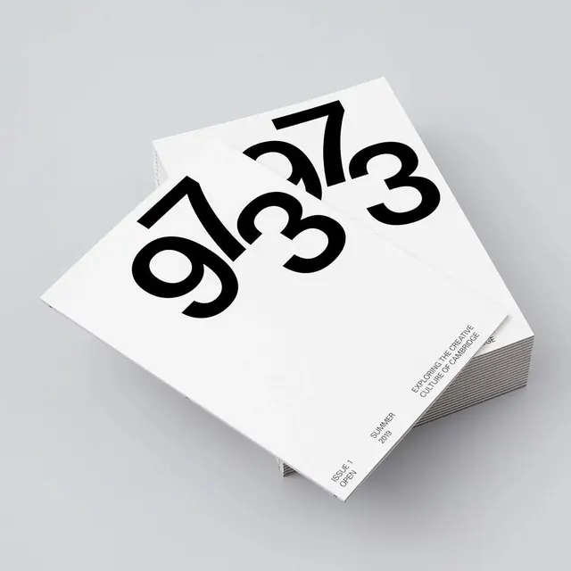 Open magazine stack with 973 cover, minimal, editorial, light
