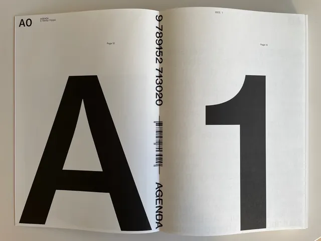 Oversized sans-serif "A" and "1" on cream pages, editorial, minimal, light