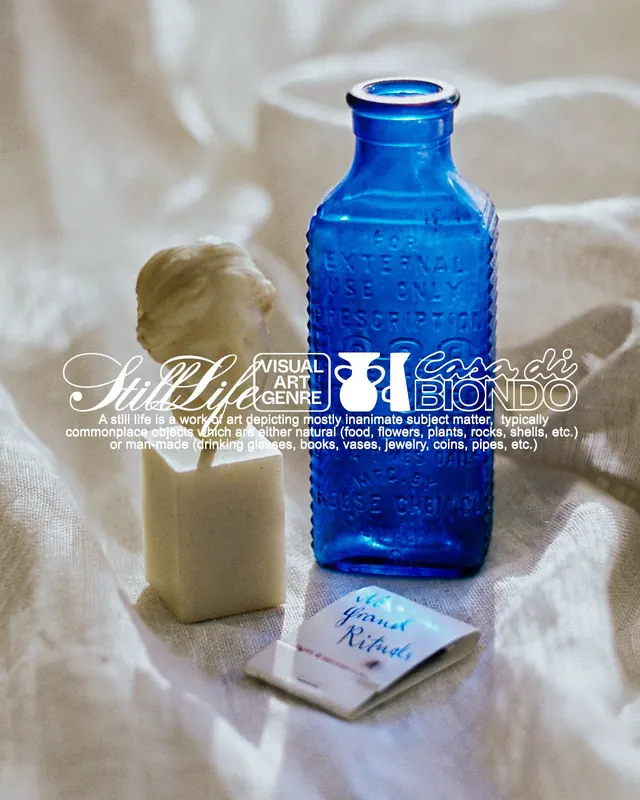 Still life: cobalt glass bottle with pale form and label, minimal, photographic, light