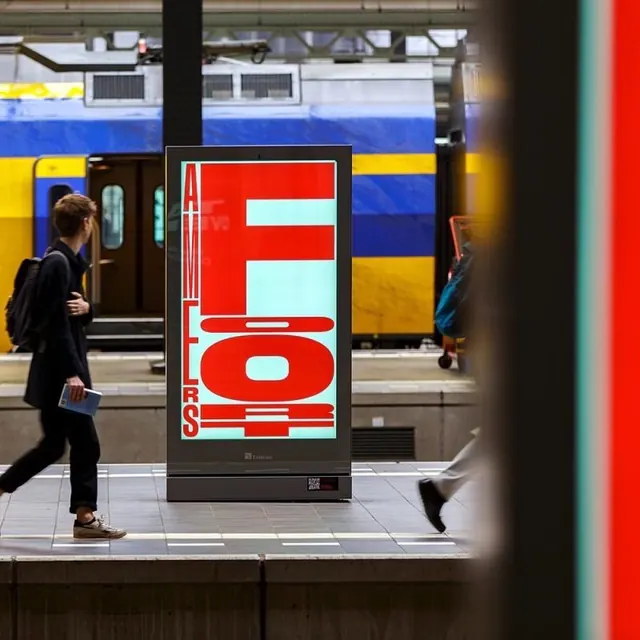 Red and cyan wayfinding display at transit station, geometric, dark
