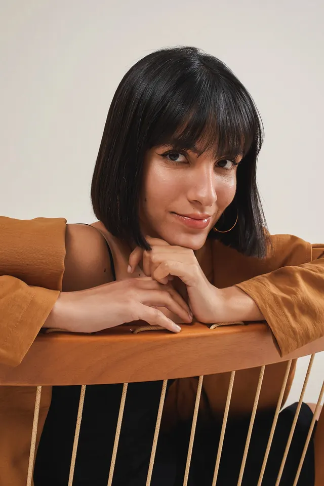 Portrait of a woman in a wooden chair, photographic, minimal, warm