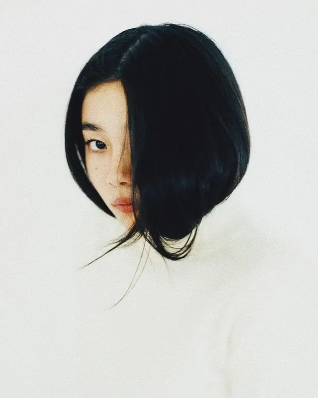 Portrait of a woman with dark hair, minimal, monochrome, high-contrast