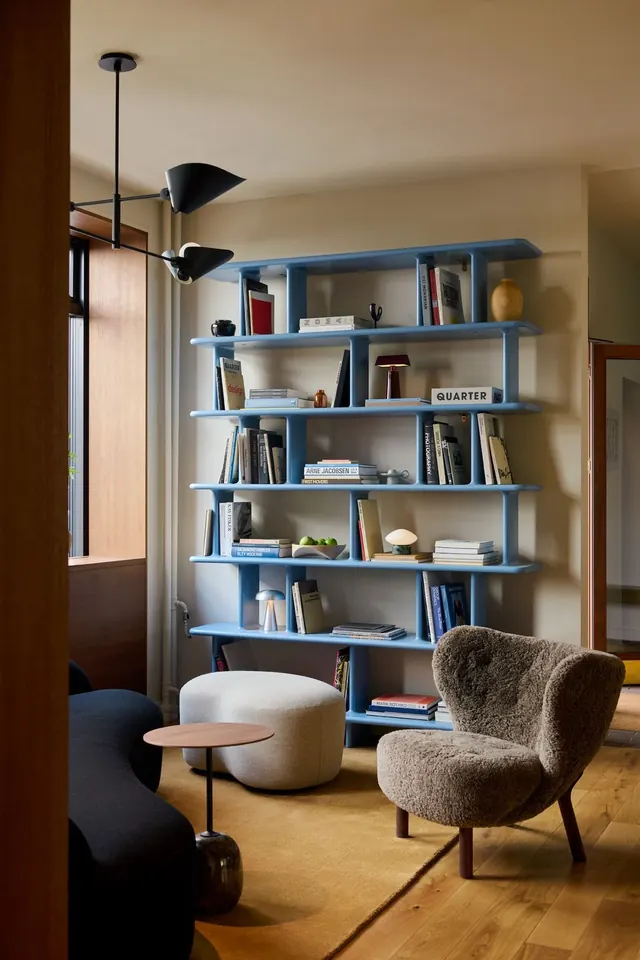 Mid-century modern living room with blue shelving, photographic, minimal, warm