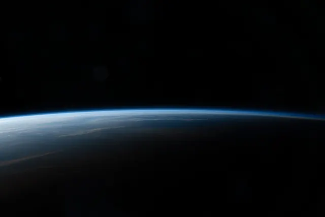Earth horizon from space with atmospheric glow, minimal, photographic, dark
