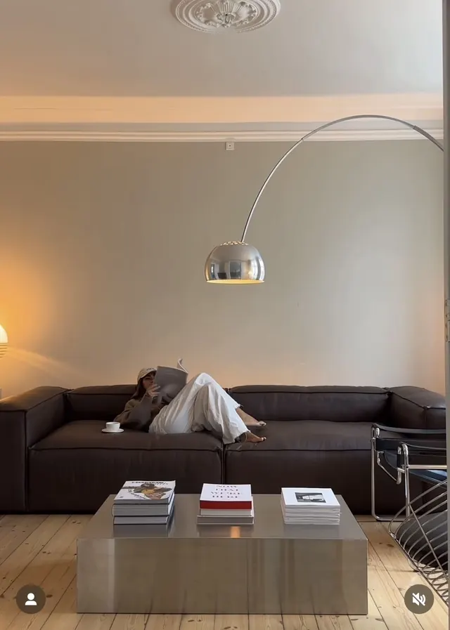 Modern minimalist interior with arc lamp and reading setup, minimal, geometric, warm