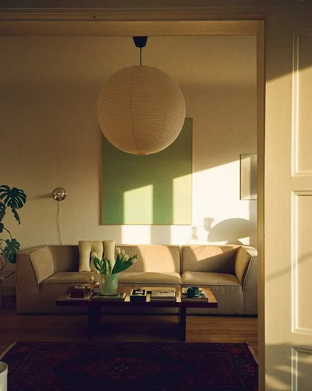 Sunlit living room with woven pendant lamp, photographic, minimal, warm