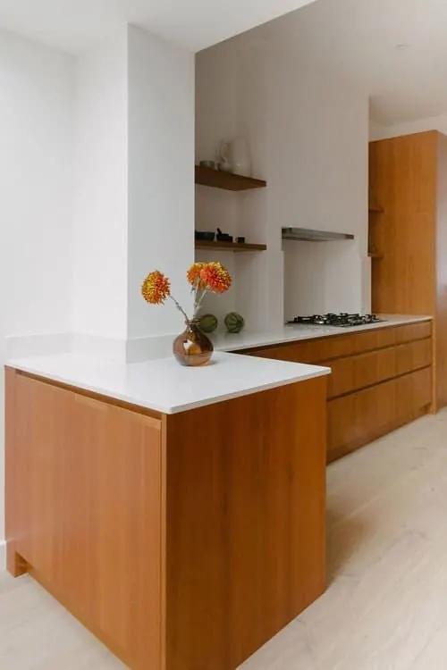 Warm wood kitchen with white countertops, corporate-clean, photographic, warm