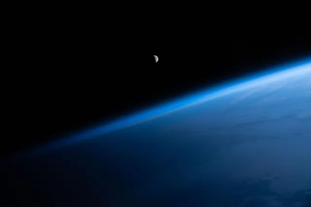 Earth from space: atmospheric curve at horizon, photographic, minimal, dark