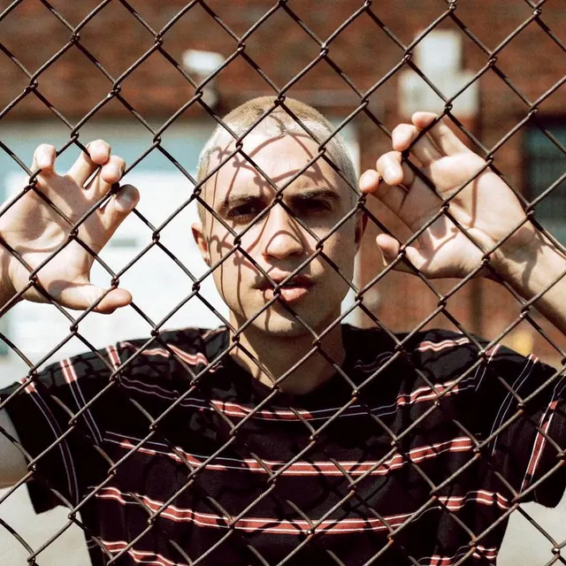 Man Behind Chain-Link Fence, photographic, brutalist, dark