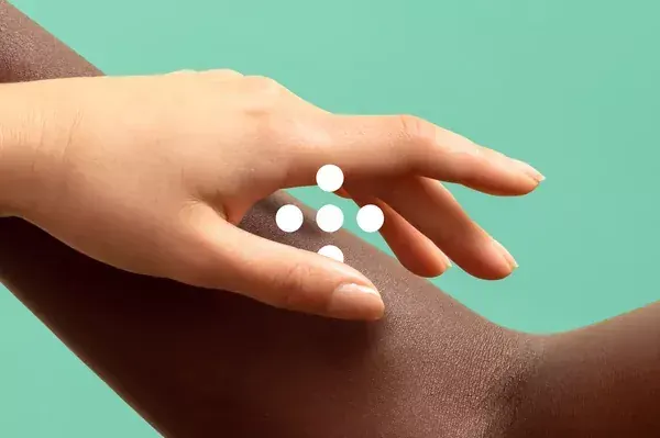Hand demonstrating skincare dots on skin, photographic, minimal, warm