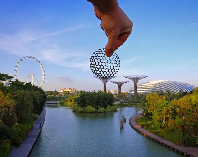 Hand Holding Globe over Theme Park, photographic, abstract, vibrant