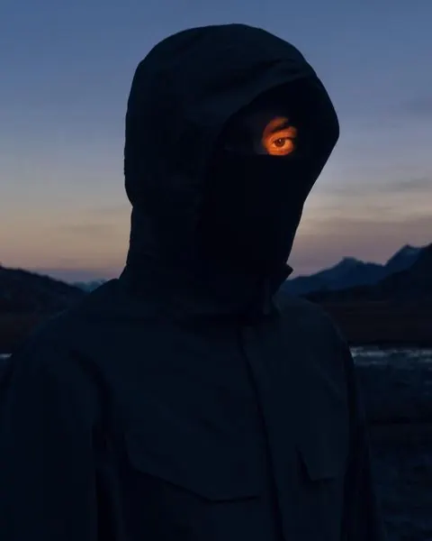 Hooded Figure with Glowing Eye, dark-mode, photographic, dark