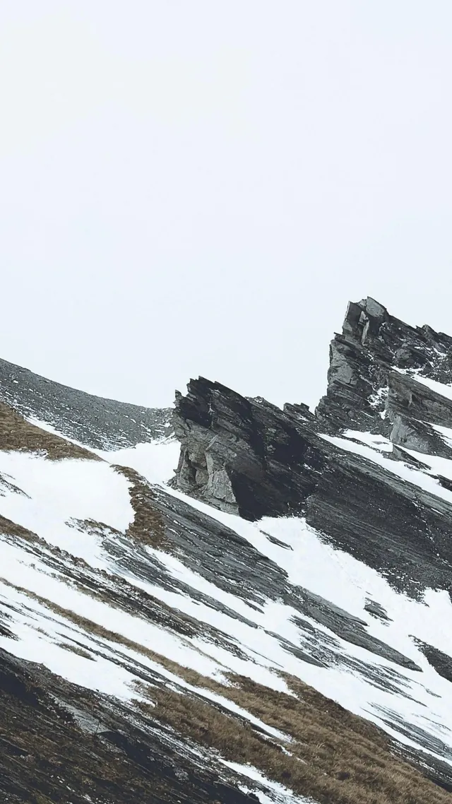 Alpine ridge with snow and dark geology, minimal, monochrome, dark